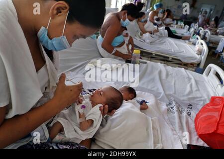 Manila, Philippinen. Dezember 2020. Eine Mutter füttert ihr Baby auf der Neugeborenenstation des Jose Fabella Krankenhauses, auch bekannt als "Babyfabrik". Dies ist eine der am meisten frequentierten Geburtenstationen der Welt und hat bereits eine noch höhere Geburtenrate aufgrund der Corona-Pandemie. Quelle: Alejandro Ernesto/DPA/Alamy Live News Stockfoto