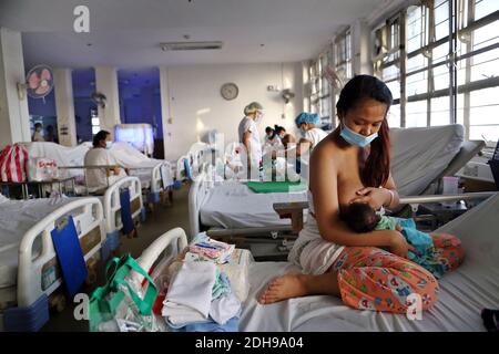 Manila, Philippinen. Dezember 2020. Eine Mutter stillt ihr Baby auf der Neugeborenenstation des Jose Fabella Krankenhauses, auch bekannt als "Babyfabrik". Dies ist eine der am meisten frequentierten Geburtenstationen der Welt und hat bereits eine noch höhere Geburtenrate aufgrund der Corona-Pandemie. Quelle: Alejandro Ernesto/DPA/Alamy Live News Stockfoto