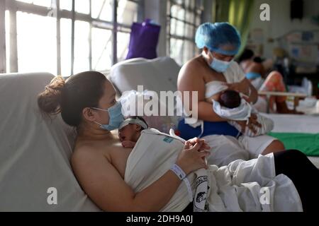 Manila, Philippinen. Dezember 2020. Zwei Mütter stillen und halten ihre Babys auf der Neugeborenenstation des Jose Fabella Hospital, auch bekannt als "Babyfabrik". Dies ist eine der am meisten frequentierten Entbindungsstationen der Welt, die aufgrund der Corona-Pandemie bereits eine noch höhere Geburtenrate hat. Quelle: Alejandro Ernesto/DPA/Alamy Live News Stockfoto