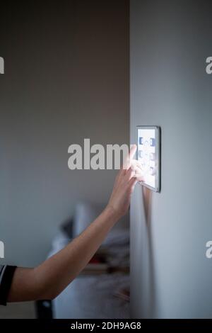 Zugeschnittenes Bild eines Jungen mit einem an der Wand montierten digitalen Tablet Zu Hause Stockfoto