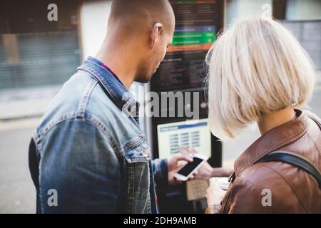 Paar kaufen Tickets aus dem Automaten am Fahrrad-Sharing-System Stockfoto