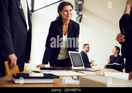 Lächelnde weibliche Profikollegen, die Kollegen während des Treffens in der Rechtswissenschaft betrachten Fest Stockfoto