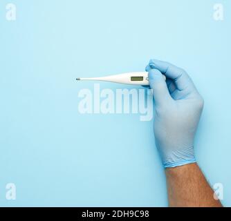 Männliche Hand in einem blauen medizinischen Handschuh hält eine weiße Kunststoffthermometer Stockfoto
