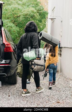 Familie Entladen Gepäck aus Elektroauto Stockfoto