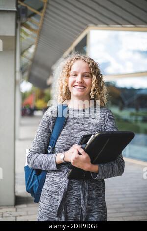 Porträt einer lächelnden jungen Frau an der Universität Stockfoto