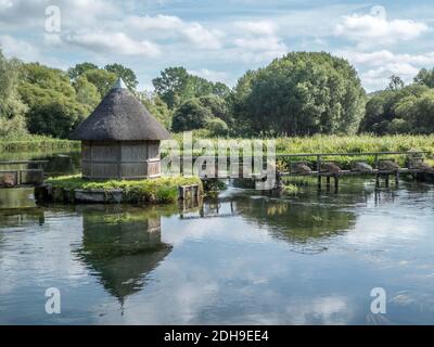 Hübsche reetgedeckte Fischerhütte am Fluss Stockfoto