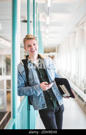 Porträt eines lächelnden jungen männlichen Studenten im Korridor der Universität Stockfoto