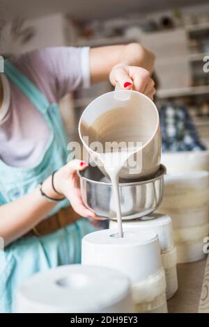 Mittelteil von jungen Töpfer Gießen Ton aus Krug in Vase In der Werkstatt Stockfoto