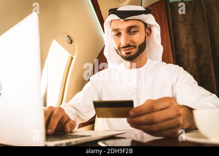 Arabischer Mann trägt eine Kandora im emirates-Stil und fliegt exklusiv Privatjet: Mittelöstlicher Geschäftsmann mit traditioneller Kleidung Exklusive BU Stockfoto