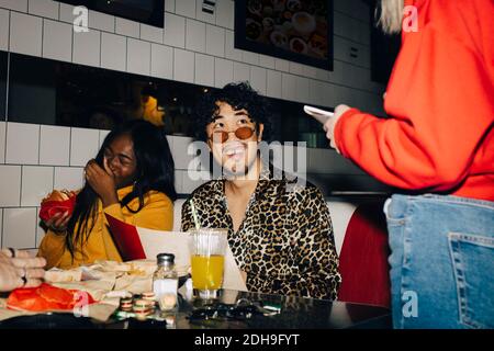 Mittelteil der Kellnerin, die Bestellung von fröhlichen männlichen und weiblichen Freunde im Café Stockfoto