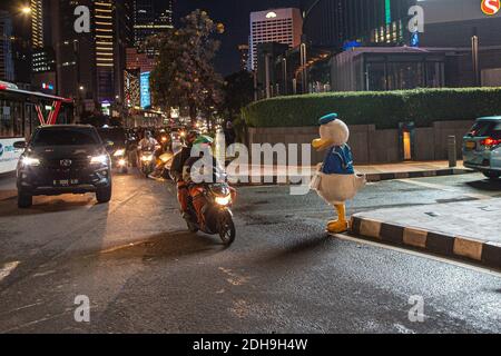 Jakarta, Indonesien. 10. Dezember 2020: Ein Mann als Donald Duck im Central Business District in Jakarta während des regnerischen Tages am 10. Dezember 2020. Präsident Joko Widodo räumte auch ein, dass Indonesiens COVID-19-Todesrate die durchschnittliche Todesrate für das Coronavirus überschritten habe, da der aktuelle CFR des Landes bei 3.1 Prozent liegt, was über dem globalen Durchschnitt von 2.32 Prozent liegt. Quelle: Ariadi Hikmal/ZUMA Wire/Alamy Live News Stockfoto