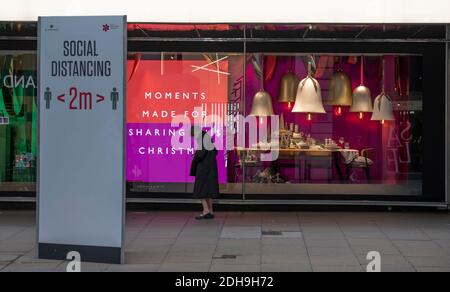 Oxford Street, London, Großbritannien. 10 Dezember 2020. Soziale Distanzierung Straßenschild und Sharing Poster in John Lewis. Quelle: Malcolm Park/Alamy Live News. Stockfoto