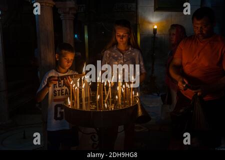 Junge Junge und Mädchen Christus Pilger aufhellen Kerzen im Inneren der Kirche des Heiligen Grabes, Jerusalem, Israel Stockfoto