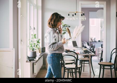 Glückliche Frau zu Hause, die am Telefon spricht Stockfoto