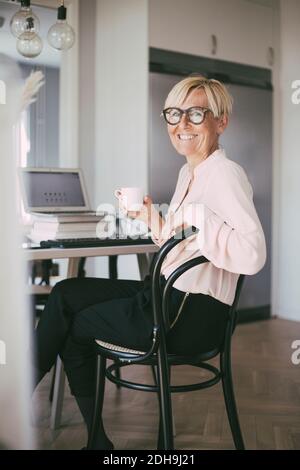 Porträt einer lächelnden Frau, die zu Hause arbeitet Stockfoto