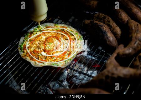 Dalat, Vietnam - Dalat Pizza - Banh Trang Nuong Detail am Morgen Markt. Lokale Imbissstände in der Nähe der Po Nagar Cham Towers Stockfoto