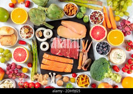Verschiedene Lebensmittel, von oben geschossen. Fleisch, Fisch, Geflügel, Meeresfrüchte, Käse, Obst, Gemüse, Nüsse, Hülsenfrüchte, Pilze, a f Stockfoto