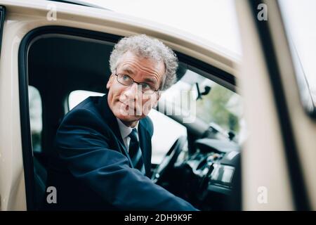 Reifen männlichen Unternehmer immer aus dem Taxi während der Geschäftsreise In der Stadt Stockfoto