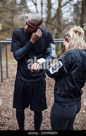 Männliche und weibliche Athleten tragen Technologien im Wald Stockfoto