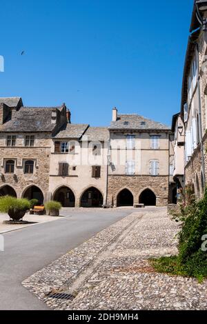 Sauveterre-de-Rouergue (Südfrankreich): Traditionelle Häuser auf dem Platz „Place des Arcades“. Fassaden von traditionellen Häusern und Bögen des ehemaligen Roy Stockfoto