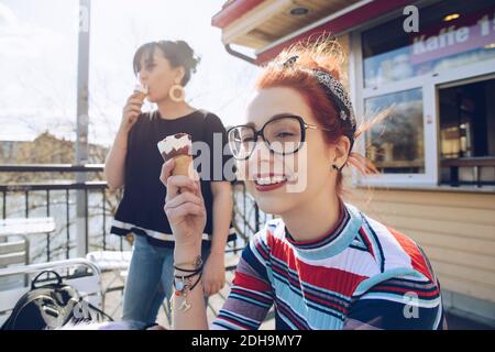 Hipster Freundinnen essen Eis im Geschäft Stockfoto