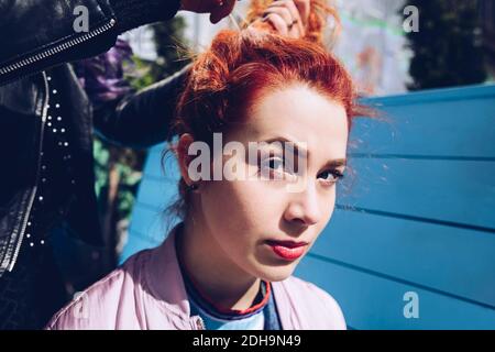 Porträt von Rotschopf Frau mit Freund binden Haare Stockfoto