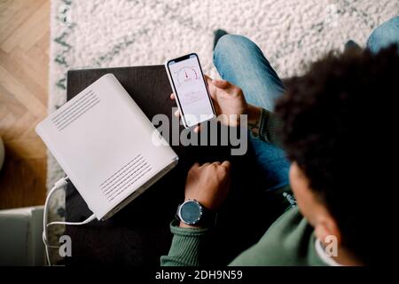 Man hatte einen Blick auf den Teenager, der die WLAN-Verbindung überprüft hatte Smartphone zu Hause Stockfoto