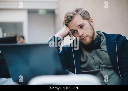 Müde Computer-Programmierer mit Laptop im Büro Stockfoto