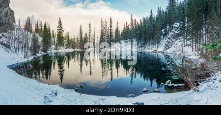 Obere Grassi Seen in der Wintersaison. Die Spiegelung der Seenoberfläche wie ein Spiegel. Canmore, Alberta, Kanada. Stockfoto