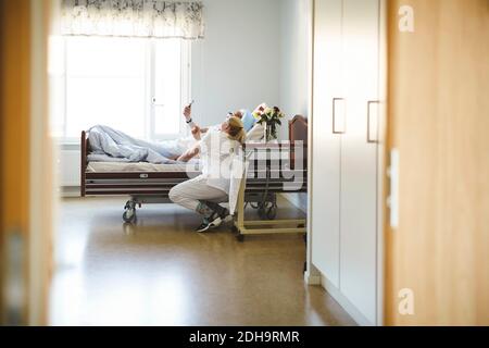 Krankenschwester und älterer Mann nehmen Selfie mit Smartphone Auf der Krankenstation Stockfoto