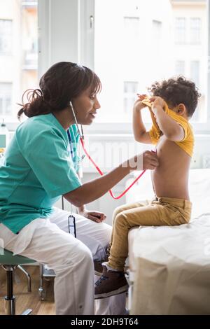 Kinderärztin beim Hören auf den Herzschlag des Jungen in der medizinischen Klinik Stockfoto