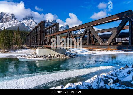 Drift Eis schwimmt auf Bow River in der frühen Wintersaison sonnigen Tag Morgen. Blauer Himmel, schneebedeckte Bergkette Mount Rundle im Hintergrund. Stockfoto