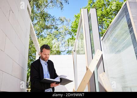 Niedrige Ansicht des Architekten beim Lesen des Dokuments im Stehen Baustelle Stockfoto