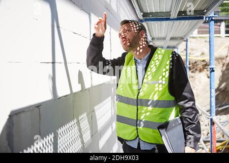 Architekt mit Datei-Analyse auf der Baustelle Stockfoto