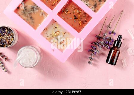 Handgemachte Seife, der Prozess der Herstellung. Glyzerin mit Kräutern, in eine spezielle Form zum Trocknen gegossen, von oben geschossen Stockfoto