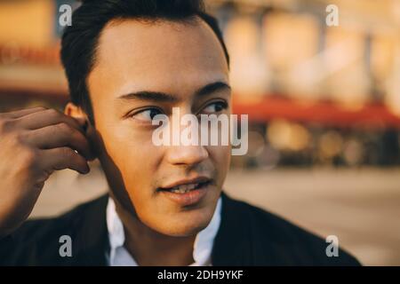 Junger Mann, der in der Stadt wegschaut Stockfoto