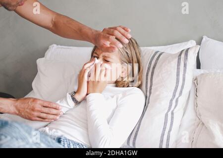 Vater berührt kranke Tochter Blasen Nase auf Bett zu Hause Stockfoto