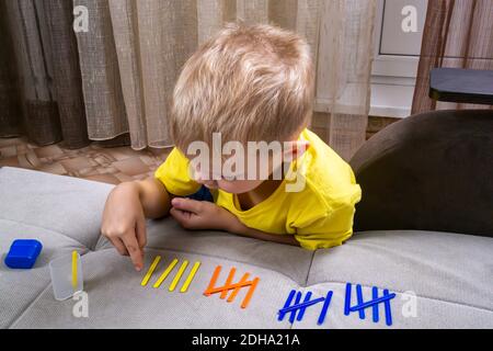 Kleiner Junge lernt mit Zählstöcken zu zählen Stockfoto