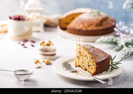 Traditionelle Weihnachtskuchenpudding mit Früchten und Nüssen mit Weihnachtsschmuck, heller Hintergrund Stockfoto