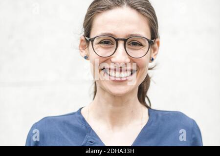 Porträt eines lächelnden jungen Unternehmers gegen die Wand Stockfoto