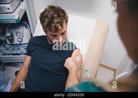 Zugeschnittenes Bild einer Krankenschwester, die einen männlichen Patienten im Krankenhaus injiziert Stockfoto