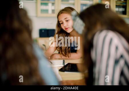 Betrachtung der weiblichen Studentin, die im Klassenzimmer studiert Stockfoto