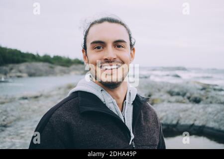 Porträt eines jungen Mannes, der am Strand lächelt Stockfoto