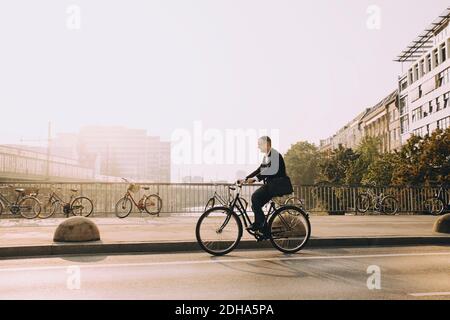 Volle Länge der reifen Mann Fahrrad auf der Straße in Stadt gegen Himmel Stockfoto