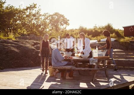 Junge multiethnische Freunde am Picknicktisch im Sommer Stockfoto