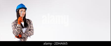 Banner, Langformat. Eine Mechanikerin, die durch einen Schraubenschlüssel schaut. Gleichstellung der Geschlechter Stockfoto