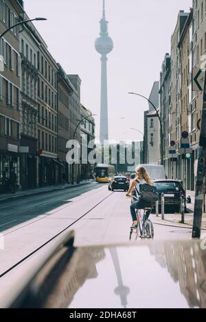 Rückansicht einer Geschäftsfrau, die auf der Straße in der Stadt Fahrrad fährt Stockfoto