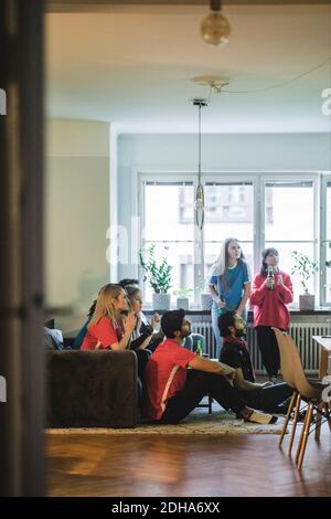 Multiethnische Freunde sehen sich das Fußballspiel zu Hause an Stockfoto