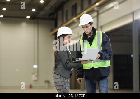 Weibliche Projektmanagerin im Business-Anzug und weiß hart hat hält einen Laptop und bespricht mit dem Chief die Produktdetails Ingenieur in einem neuen Flugzeug manu Stockfoto