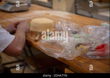 Eine selektive Aufnahme der Herstellung von Marzipan-Kuchen auf dem Tisch. Dekoration Kuchen in Waagan Bäckerei, Tynset Stockfoto